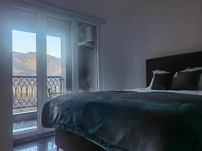 a bedroom with a bed with a view of a balcony at Apartman Nermin in Travnik