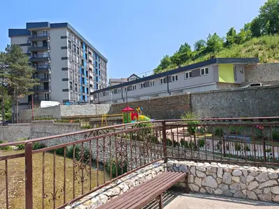 a wooden bench sitting next to a building at Apartman Nermin in Travnik