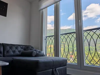 a living room with a couch and a large window at Apartman Nermin in Travnik