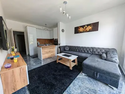 a living room with a couch and a kitchen at Apartman Nermin in Travnik