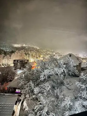 a city with snow covered trees and buildings at Apartman Nermin in Travnik