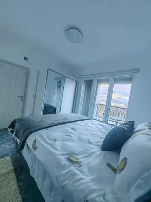 a large bed in a room with a large window at Apartman Nermin in Travnik