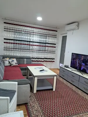 a living room with a couch and a tv at Apartmani Jaca in Tuzla