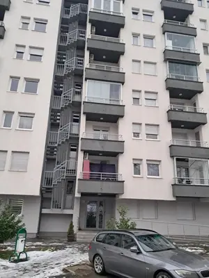 a car parked in front of a tall building at Apartmani Jaca in Tuzla
