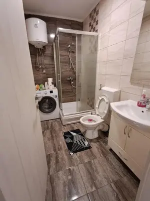 a bathroom with a shower and a toilet and a sink at Apartmani Jaca in Tuzla