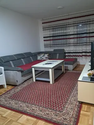 a living room with a couch and a table at Apartmani Jaca in Tuzla
