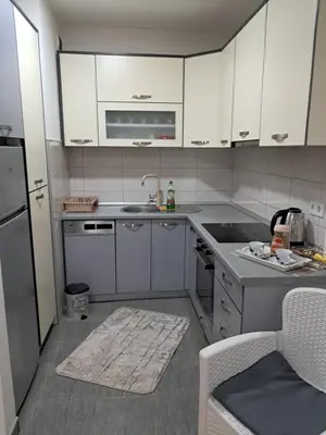a small kitchen with white cabinets and a sink at Apartmani Jaca in Tuzla