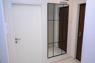 a mirror in a room next to a door at Apartment Feel Banja Luka in Banja Luka