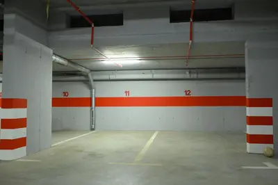 an empty parking garage with red and white stripes on the walls at Apartment Feel Banja Luka in Banja Luka