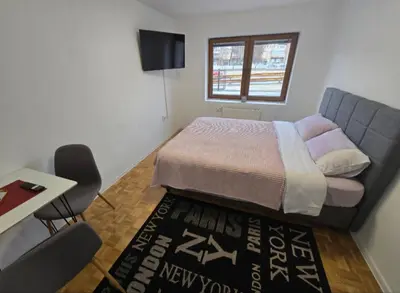 a small bedroom with a bed and a table and chair at Plavi most in Tuzla