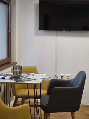 a room with a table and chairs and a tv at Plavi most in Tuzla