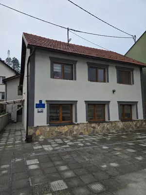 a white house with brown windows at Plavi most in Tuzla