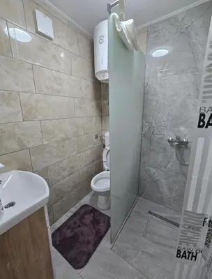 a bathroom with a shower and a toilet and a sink at Plavi most in Tuzla