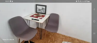 a small table with two chairs in a room at Plavi most in Tuzla