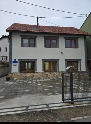 a white house with a fence in front of it at Plavi most in Tuzla