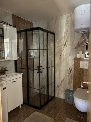 a bathroom with a shower with a sink and a toilet at Crown Apartmani Vlašić in Vlasic