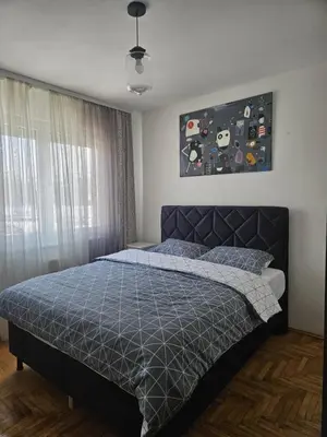 a bedroom with a bed with a blue comforter at Industry in Banja Luka