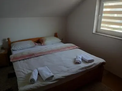 a bedroom with a bed with two pairs of towels on it at Apartman ZM in Livno