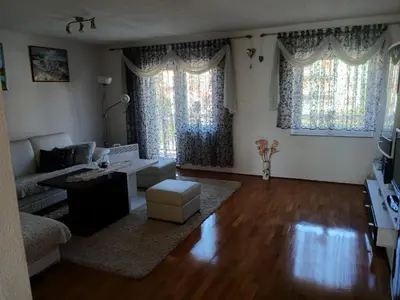 a living room with a couch and two windows at Apartman ZM in Livno