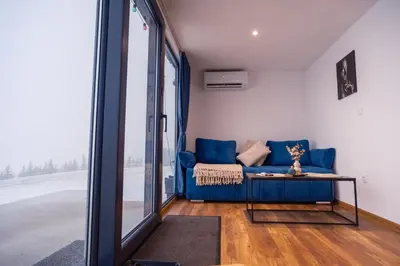 a living room with a blue couch and a table at Container House Kod Čupe in Kupres