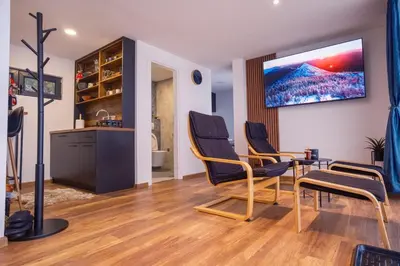 a room with two chairs and a table and a tv at Container House Kod Čupe in Kupres