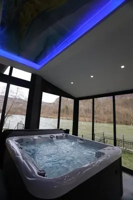 a large hot tub in a room with windows at Villa Mali Vuk in Banja Luka