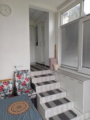 a room with stairs and a window with a clock at Vikendica Kozlovac in Tuzla