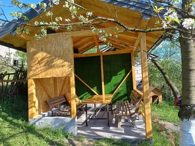 a wooden gazebo with a table and chairs at Vikendica Kozlovac in Tuzla
