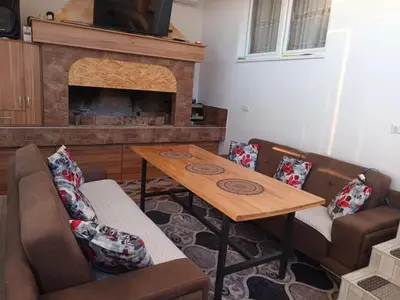 a living room with a table and a fireplace at Vikendica Kozlovac in Tuzla