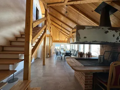a living room with a staircase and a dining room at Apartman Santro in Kupres