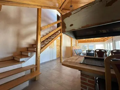 a staircase in a tiny house with a table and chairs at Apartman Santro in Kupres