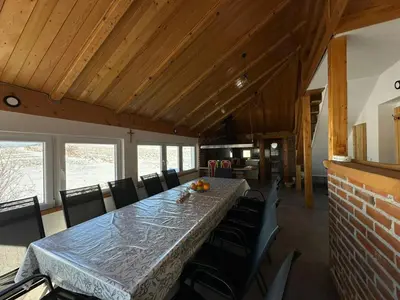 a dining room with a long table and chairs at Apartman Santro in Kupres