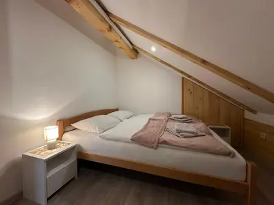 a bedroom with a bed and a night stand with a lamp at Apartman Santro in Kupres