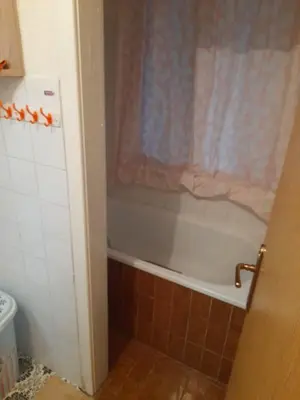 a bathroom with a bath tub and a toilet at Palma Apartman in Tuzla