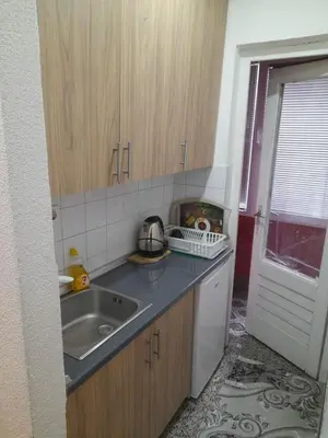 a small kitchen with a sink and a window at Palma Apartman in Tuzla