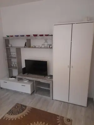 a living room with a tv and a white cabinet at Palma Apartman in Tuzla