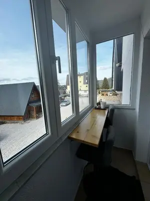 a wooden table in a room with two windows at Winter Nights Vlasic in Vlasic