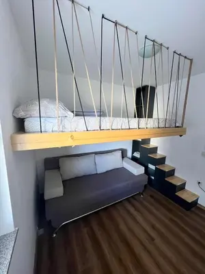 a loft bed with a couch under a shelf at Winter Nights Vlasic in Vlasic