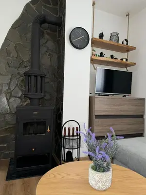 a living room with a stove and a table at Winter Nights Vlasic in Vlasic