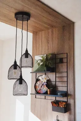 three pendant lights hanging from a wall with a clock at Pine apartment Vlašić in Vlasic