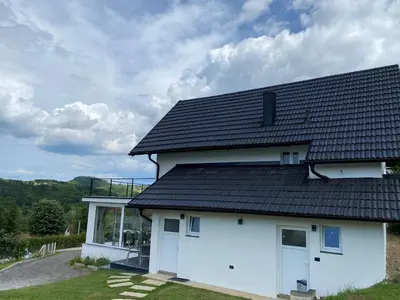 a white house with a black roof at Relax House in Banja Luka