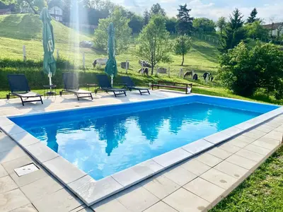 a swimming pool with blue water in a yard at Relax House in Banja Luka