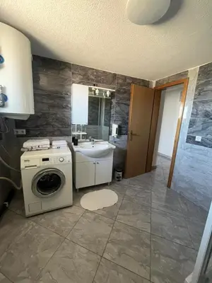 a bathroom with a washing machine and a sink at Motel i Restoran Ana in Donji Svilaj