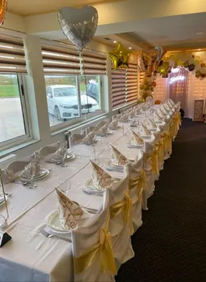 a row of tables in a room with white tablecloths at Motel i Restoran Ana in Donji Svilaj