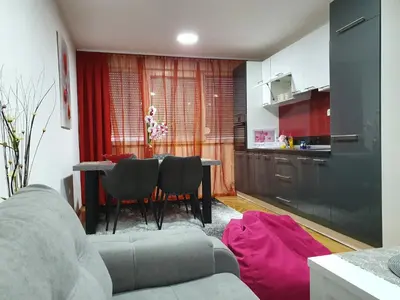 a living room with a couch and a table with chairs at Apartment Ema with garage in Velika Kladuša
