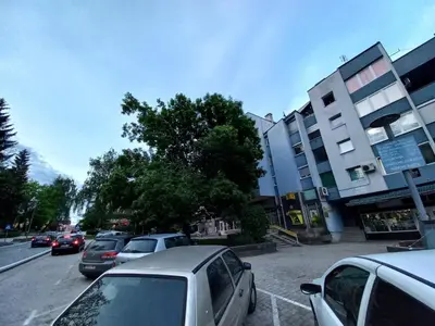 a parking lot with cars parked in front of a building at Apartment Ema with garage in Velika Kladuša