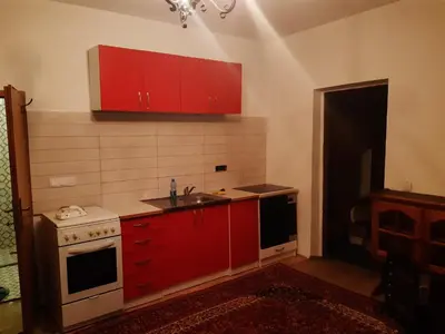 a kitchen with red cabinets and a sink at Apartment 2KM from city center in Zenica