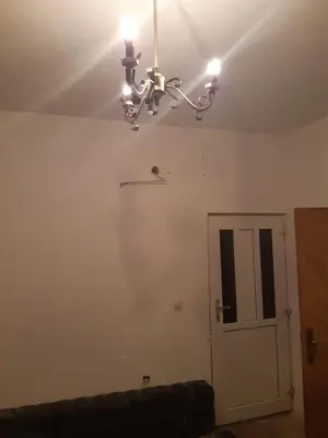 a room with a ceiling with a chandelier and a door at Apartment 2KM from city center in Zenica