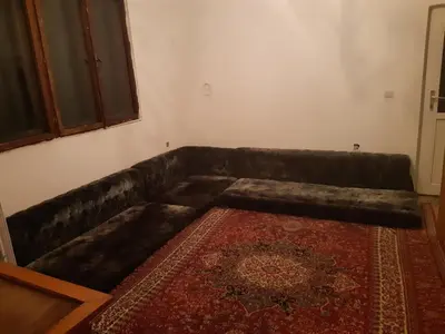 a brown leather couch in a living room with a rug at Apartment 2KM from city center in Zenica