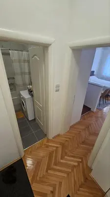 a room with a hallway with a wooden floor at Stan na dan G & V in Prijedor